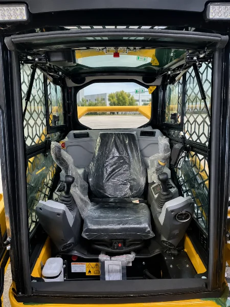Cabin interior of the CDM315T with protected operator seat, controls and safety grid visible.