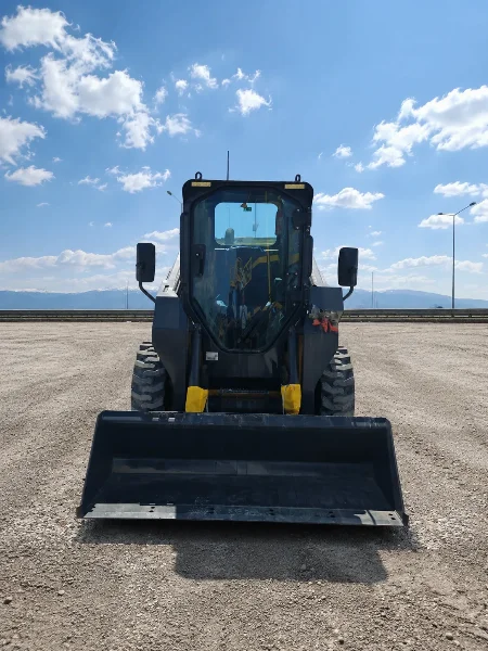 XCMG XC7-SR08 mini skid steer loader front view with bucket and enclosed operator cabin.