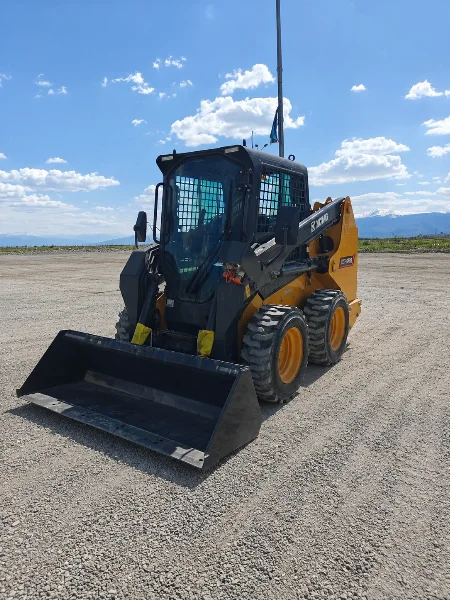 XCMG XC7-SR08 mini skid steer loader front-left view with bucket, enclosed cabin and loader arms.