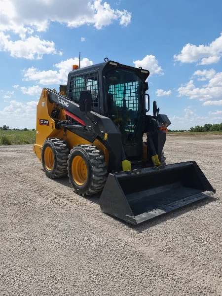 XCMG XC7-SR08 compact skid steer loader front-right view with bucket on a gravel worksite.