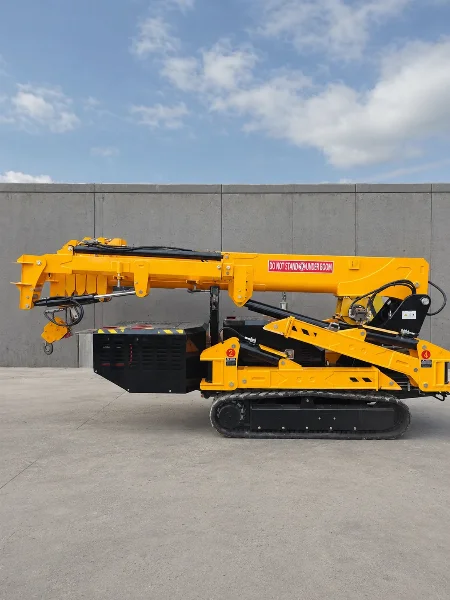 BAUTRAX SPC50 spider crane in compact transport position on rubber tracks, side view against a blue sky